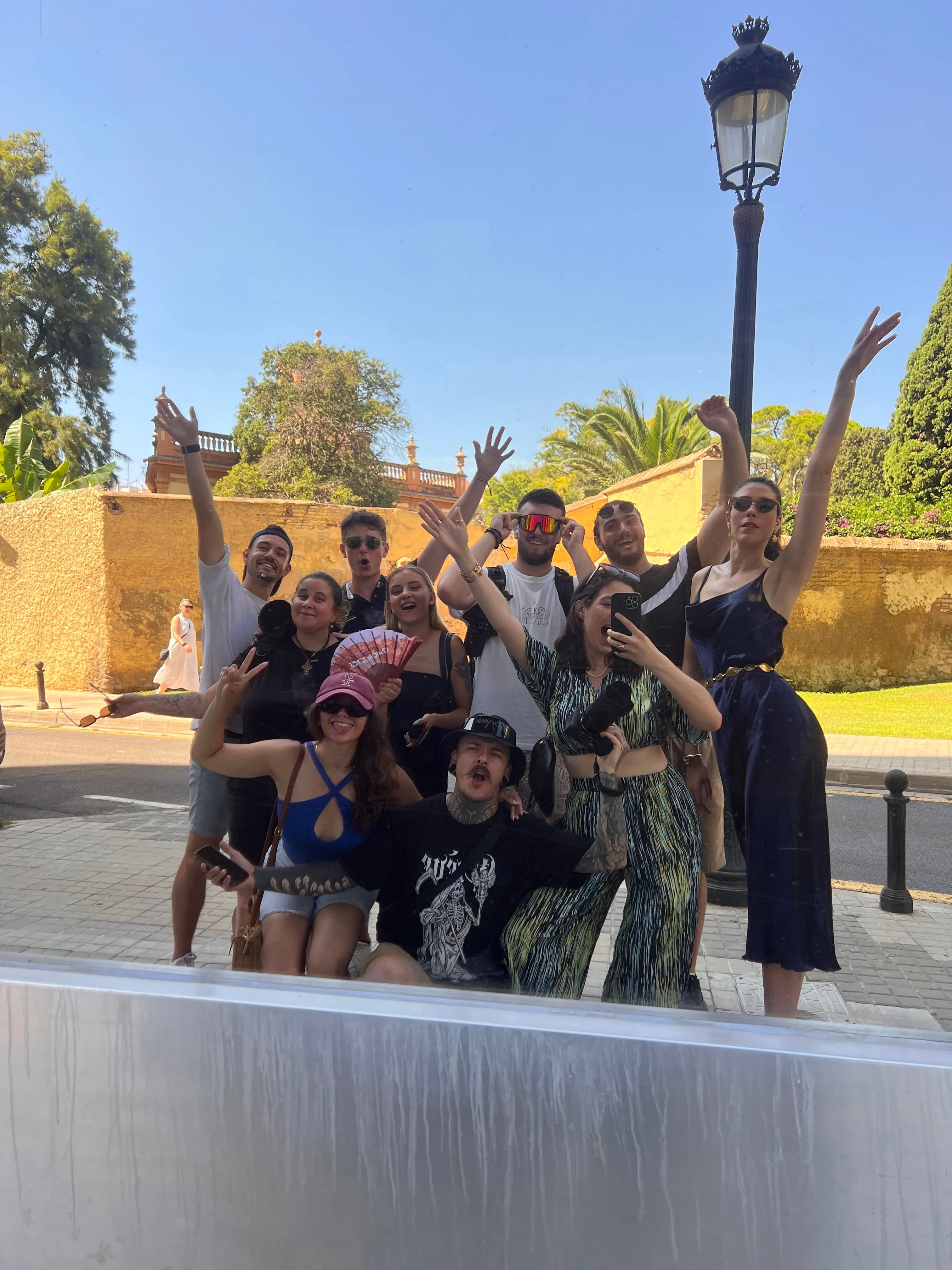 Le groupe de l'édition Valencia, bras levés, sous un lampadaire et des palmiers.