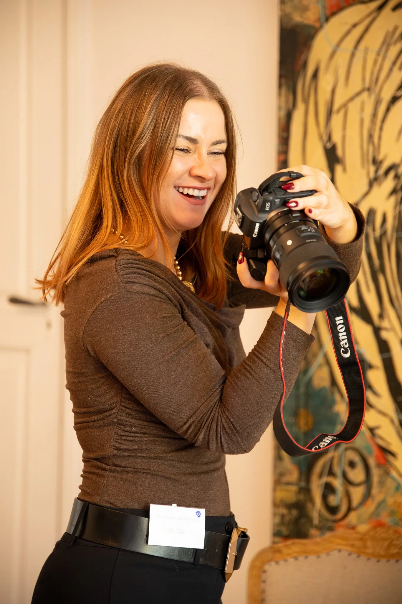 Une photographe éclate de rire en regardant l'écran de son appareil Canon.