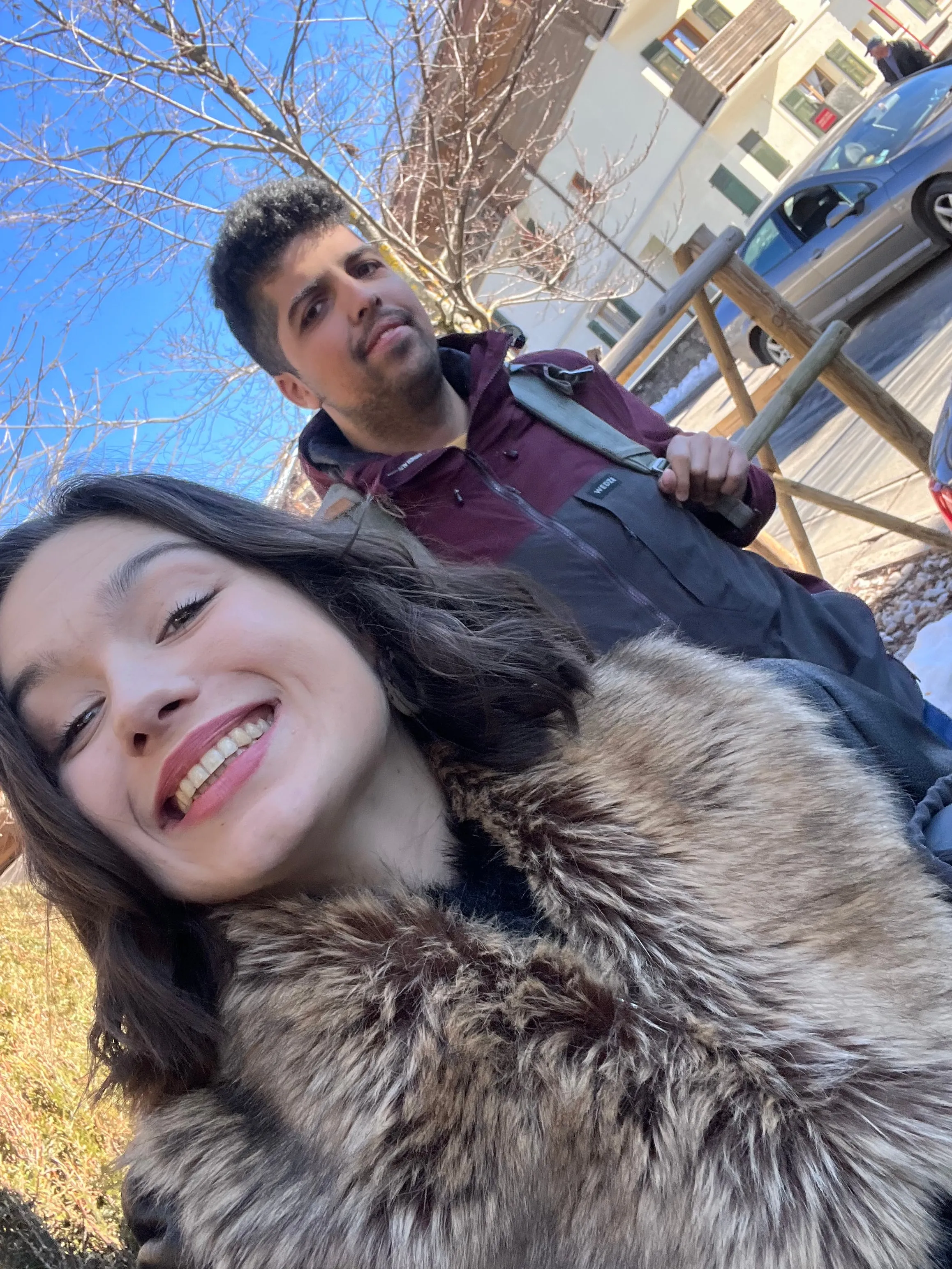 Selfie souriant d'une participante en col de fourrure et d'un participant, au soleil.